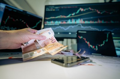 Eurobankovky v ruke pri počítači