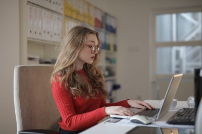 Žena sedí za stolom a pracuje na počítači